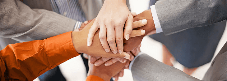 Diverse business team stacking hands together